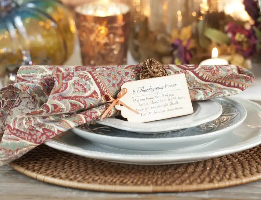A Thanksgiving table setting with a place card that has a Thanksgiving Prayer written on it